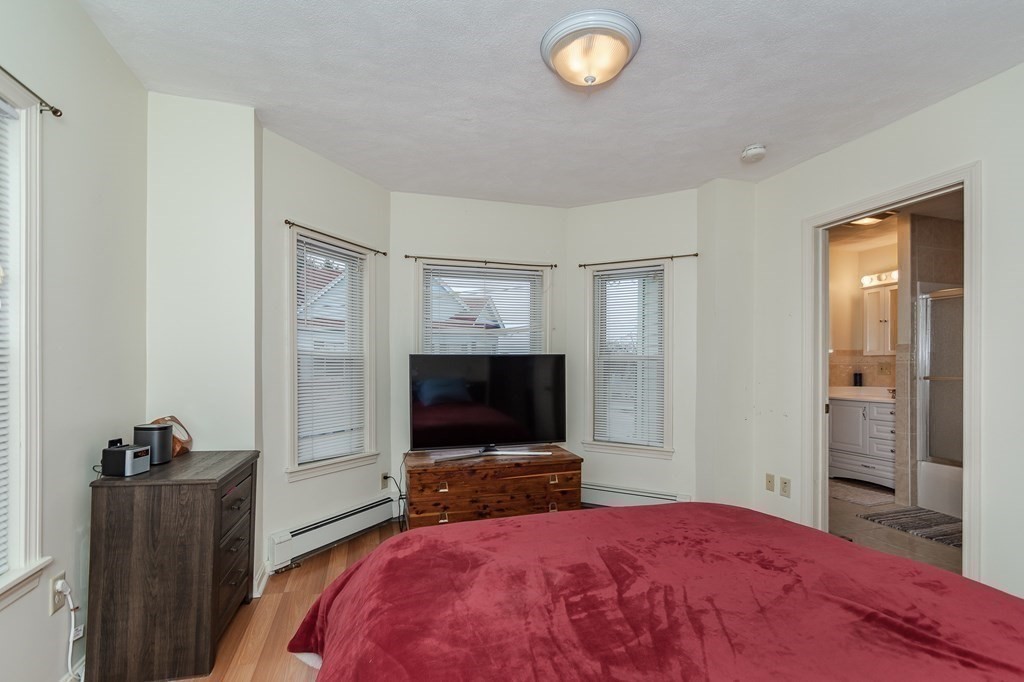 246 Haven Street, Unit 2 Reading, MA 01867 - Photo 17 of 23 a bedroom with a bed and a flat screen tv