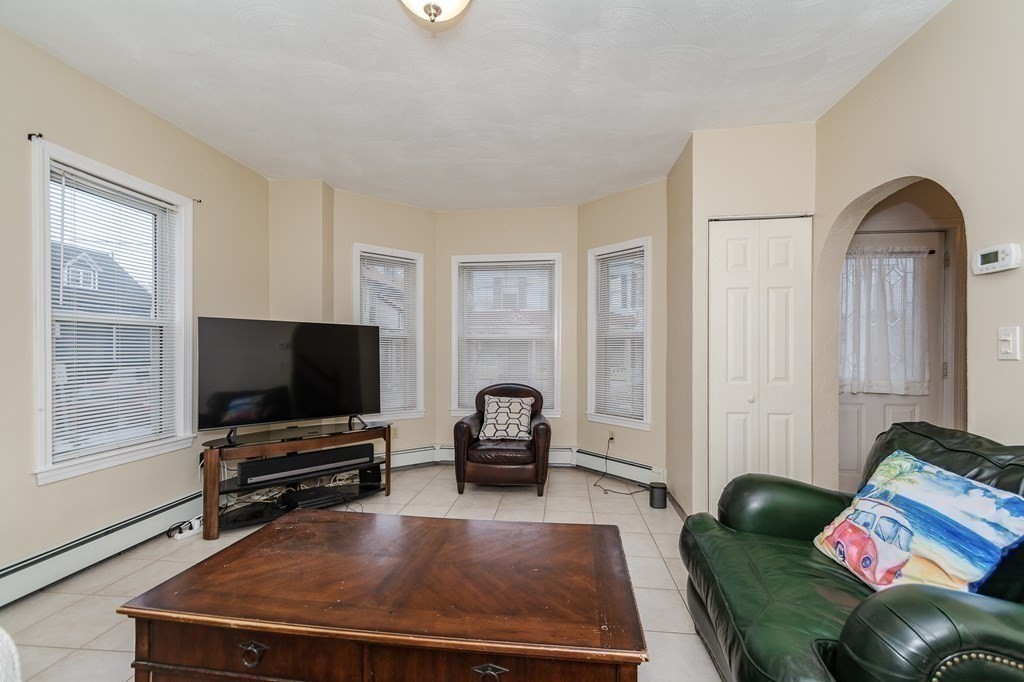 246 Haven Street, Unit 2 Reading, MA 01867 - Photo 5 of 23 a living room with furniture and a flat screen tv