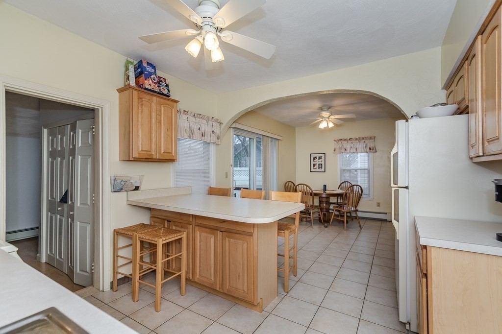 246 Haven Street, Unit 2 Reading, MA 01867 - Photo 8 of 23 a view of a kitchen with dining area a sink and stainless steel appliances