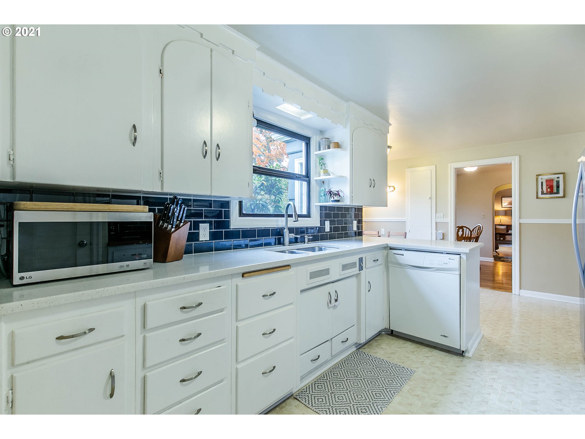 249 8th Street Springfield, OR 97477 - Photo 16 of 32 a kitchen with granite countertop white cabinets and white appliances