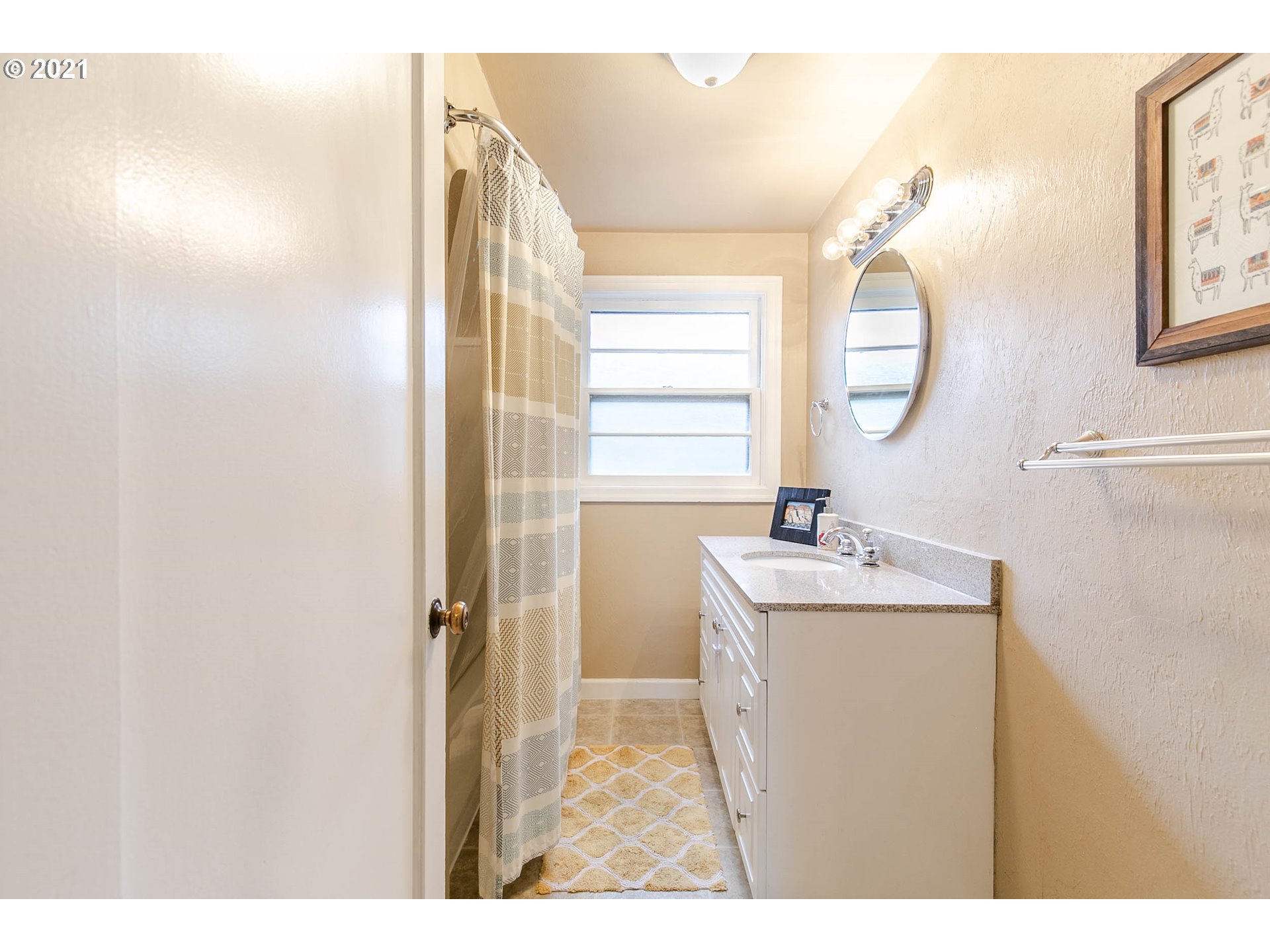 249 8th Street Springfield, OR 97477 - Photo 21 of 32 a bathroom with a sink a mirror and a shower