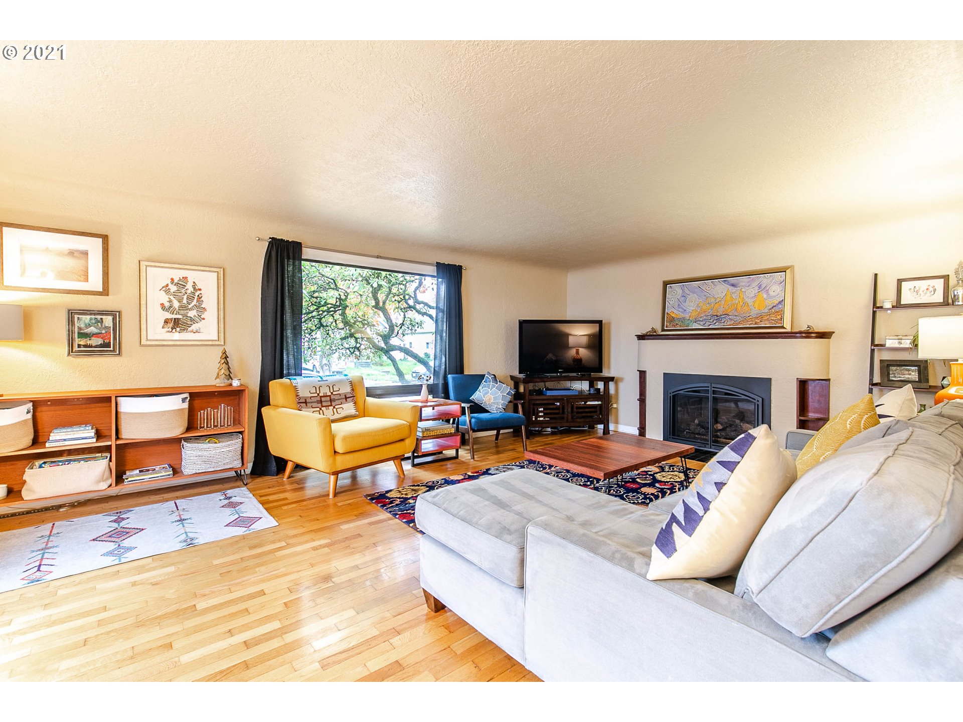 249 8th Street Springfield, OR 97477 - Photo 5 of 32 a living room with furniture a rug and a fireplace