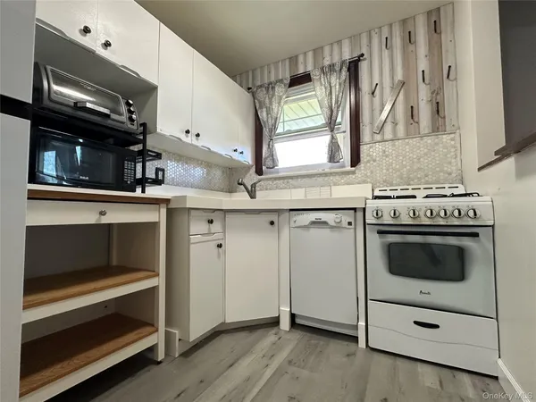 a kitchen with white cabinets and appliances