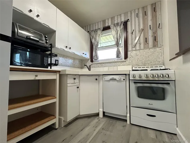 a kitchen with white cabinets and appliances
