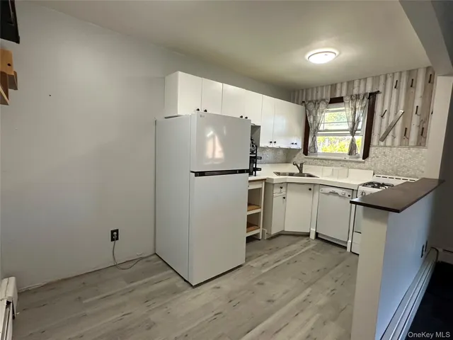 a kitchen with a sink cabinets stainless steel appliances and window