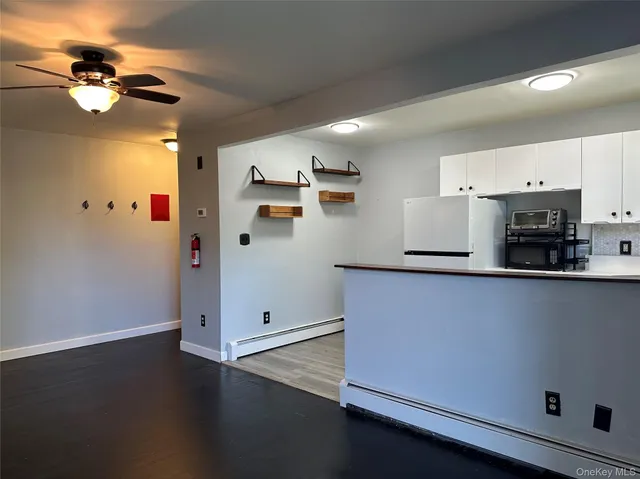 a view of an empty room with a ceiling fan and window