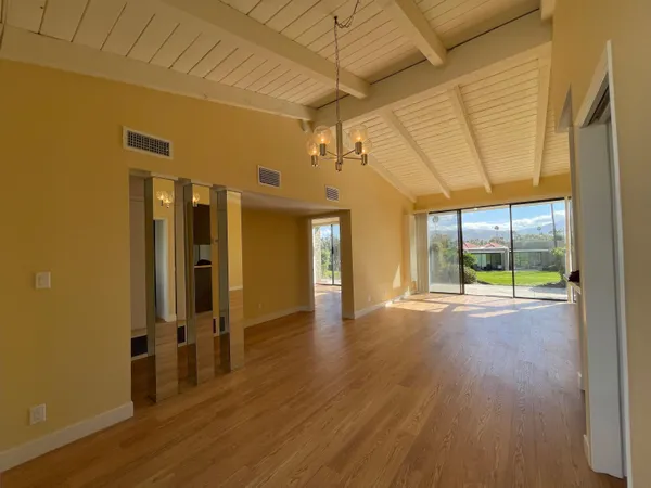 a view of a hallway with wooden floor and windows