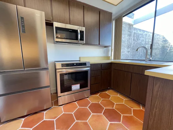 a kitchen with stainless steel appliances granite countertop a refrigerator and a sink