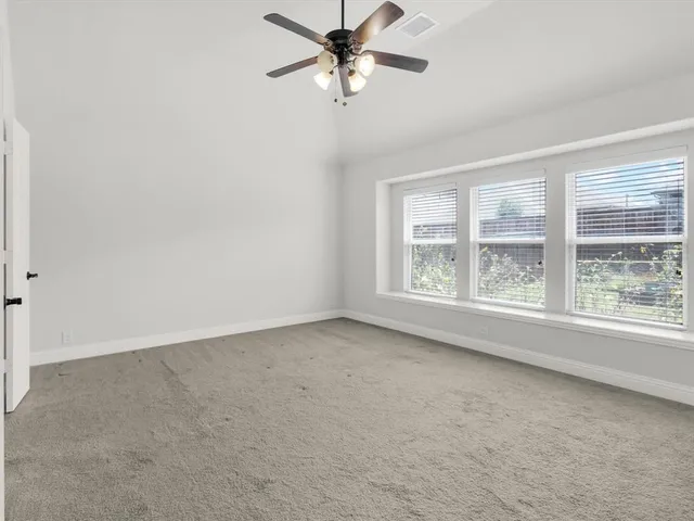 an empty room with a window and a ceiling fan