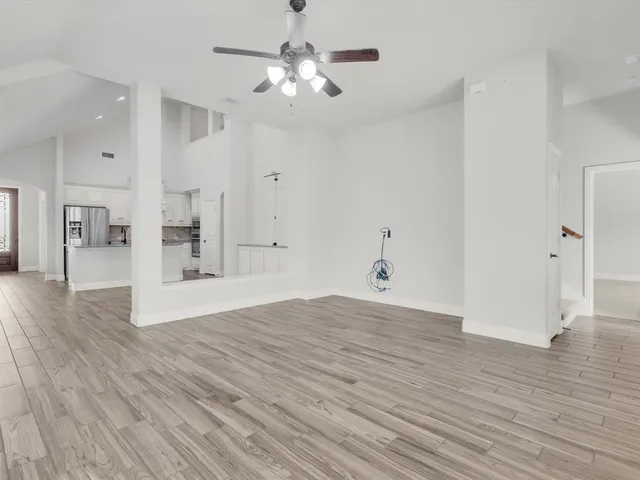 a view of empty room with wooden floor