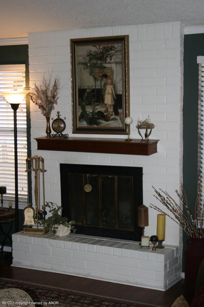 2702 Shadow Court Amarillo, TX 79110 - Photo 12 of 23 a living room with a fireplace and potted plant