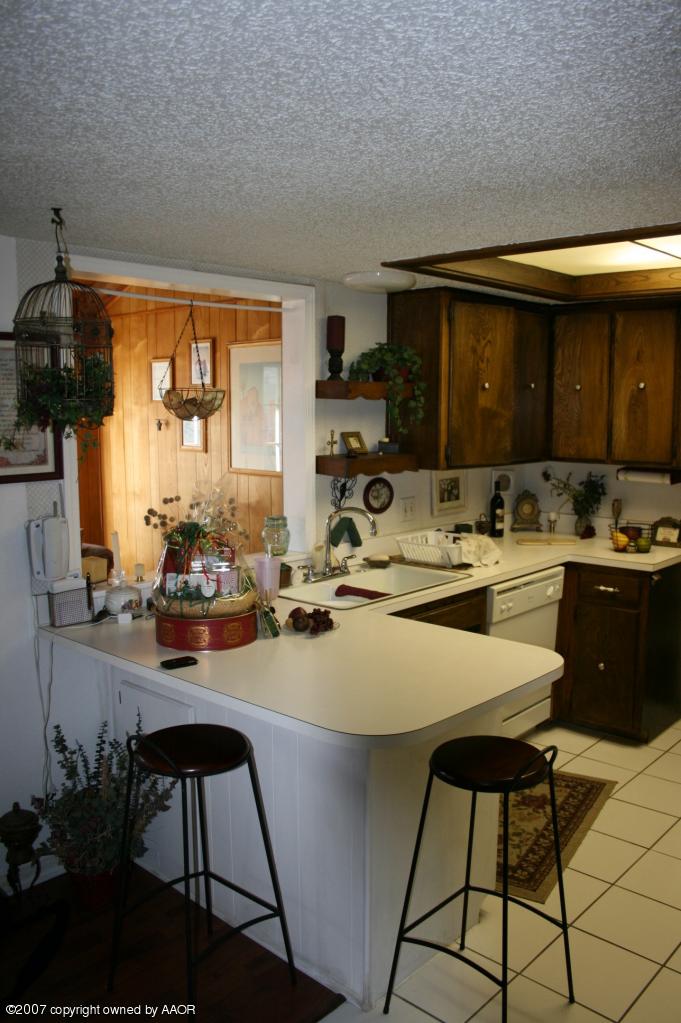 2702 Shadow Court Amarillo, TX 79110 - Photo 15 of 23 a kitchen with a sink and chairs