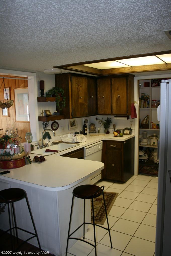 2702 Shadow Court Amarillo, TX 79110 - Photo 16 of 23 a kitchen with a sink a stove and chairs