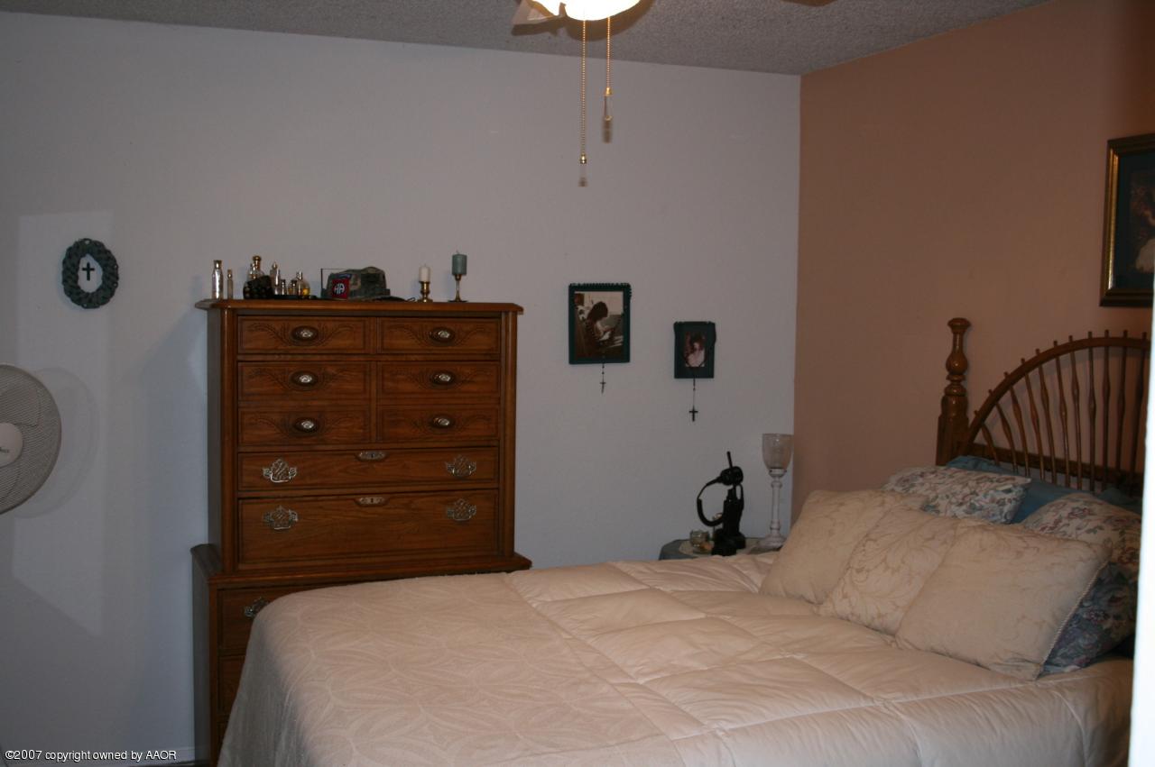 2702 Shadow Court Amarillo, TX 79110 - Photo 3 of 23 a bedroom with a bed and a lamp on the dresser