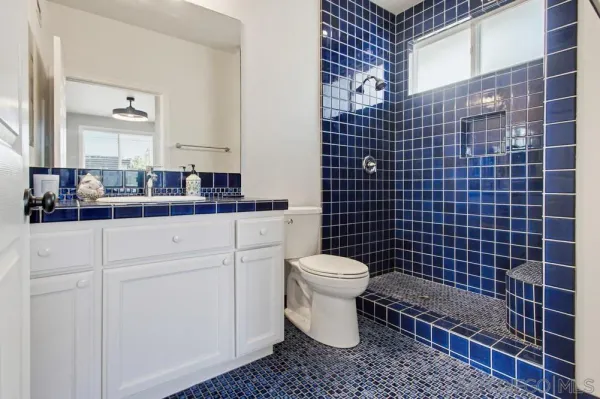 a view of a workspace with furniture and a bathroom