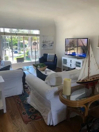 a living room with furniture and a floor to ceiling window