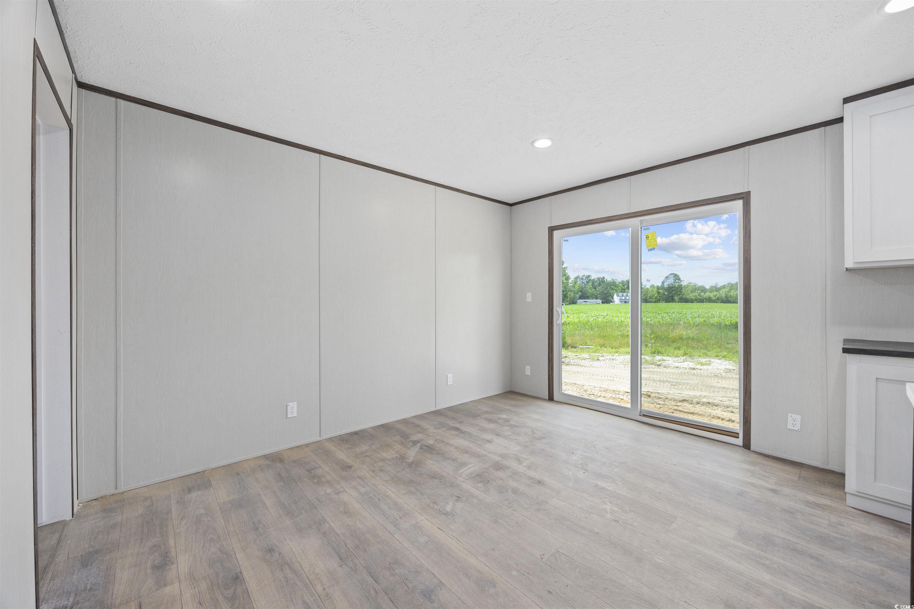 1315 Rabbit Lane Conway, SC 29526 - Photo 10 of 27 Unfurnished living room featuring light wood-style floors, recessed lighting, ornamental molding, and a decorative wall