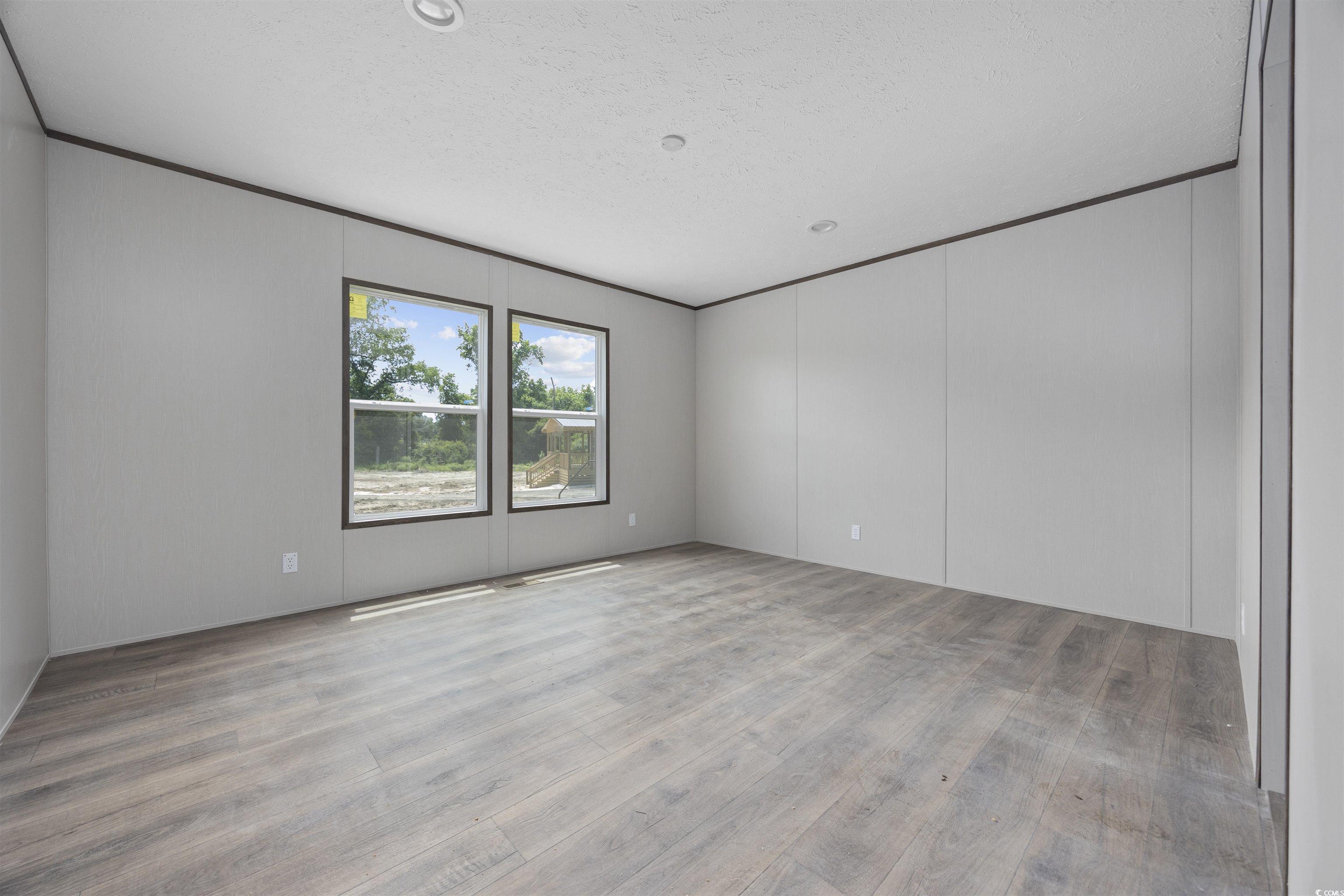 1315 Rabbit Lane Conway, SC 29526 - Photo 14 of 27 Unfurnished room featuring light wood-style flooring, a textured ceiling, and crown molding