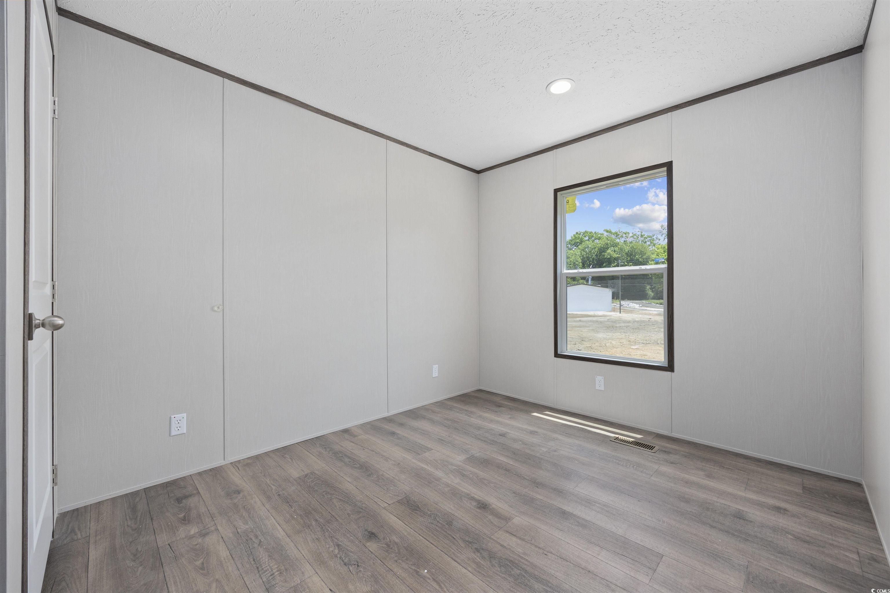 1315 Rabbit Lane Conway, SC 29526 - Photo 24 of 27 Empty room featuring wood finished floors, a textured ceiling, ornamental molding, and recessed lighting
