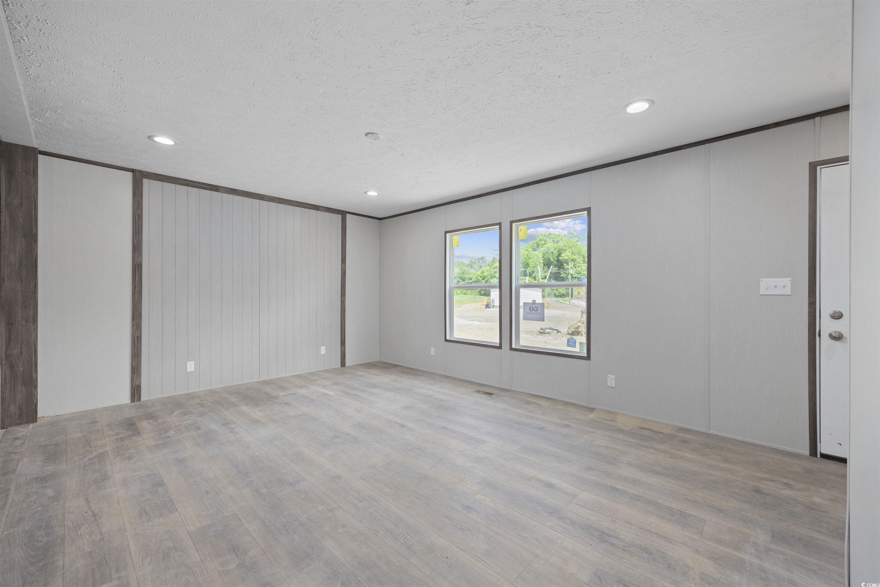 1315 Rabbit Lane Conway, SC 29526 - Photo 3 of 27 Empty room with a textured ceiling, wood finished floors, recessed lighting, and wood walls