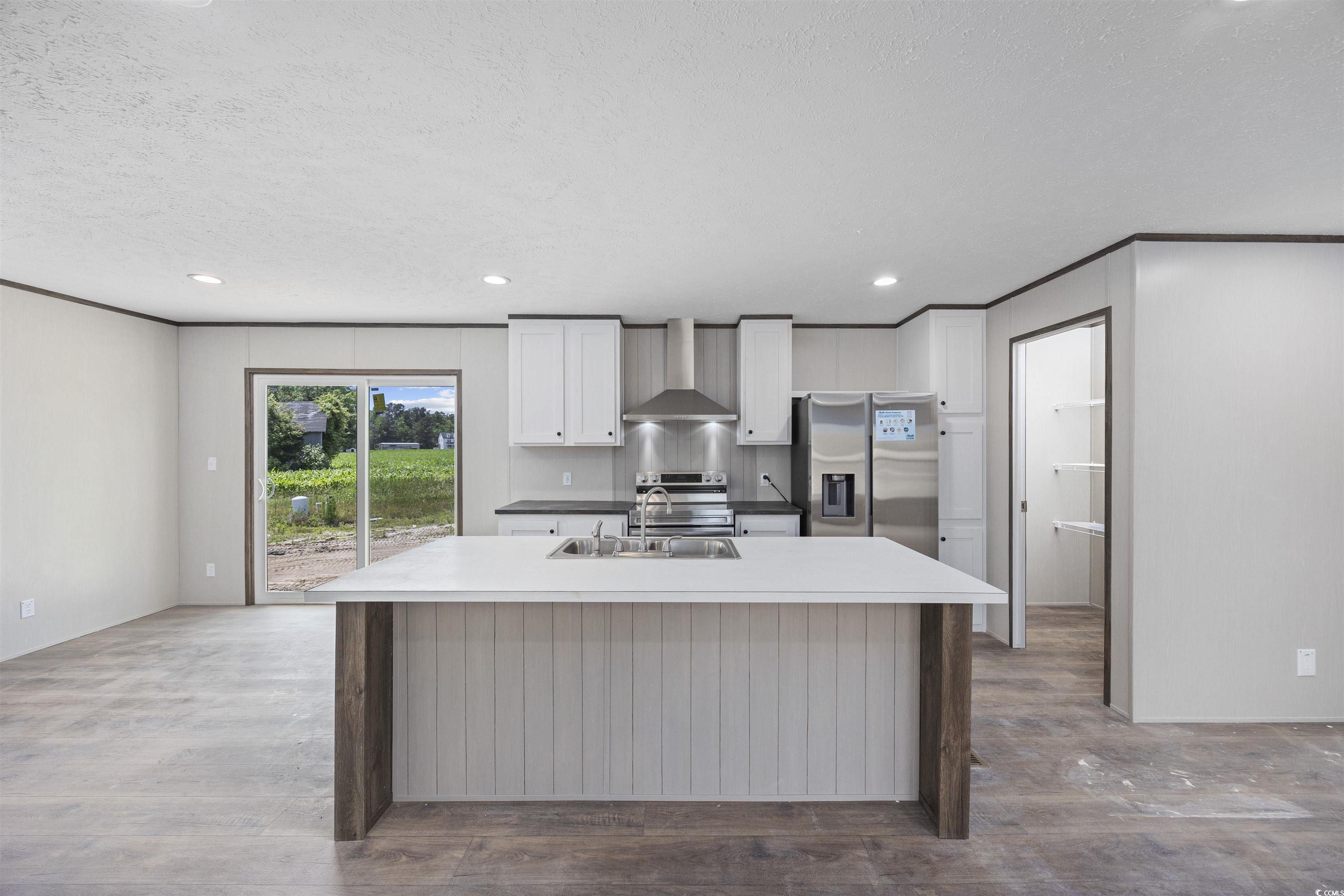 1315 Rabbit Lane Conway, SC 29526 - Photo 7 of 27 Kitchen featuring white cabinetry, a center island with sink, appliances with stainless steel finishes, recessed lighting, and wall chimney range hood