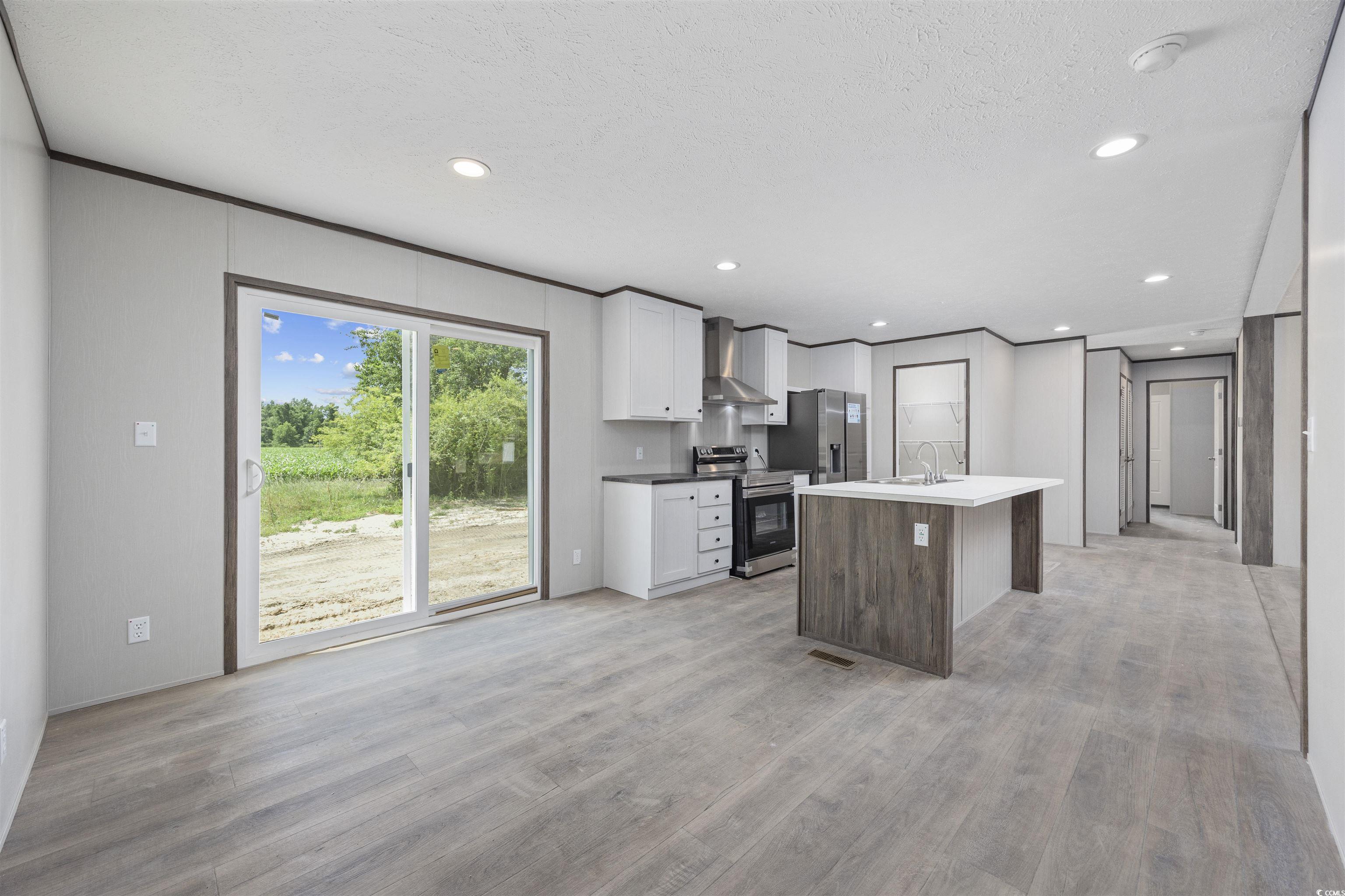1315 Rabbit Lane Conway, SC 29526 - Photo 9 of 27 Kitchen with white cabinets, stainless steel appliances, wall chimney exhaust hood, light wood finished floors, and recessed lighting