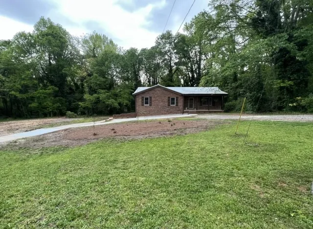 a front view of a house with a yard and trees