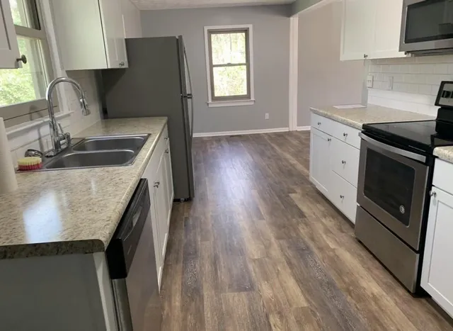 a view of an empty room window and wooden floor