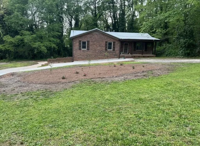 a front view of a house with yard and green space