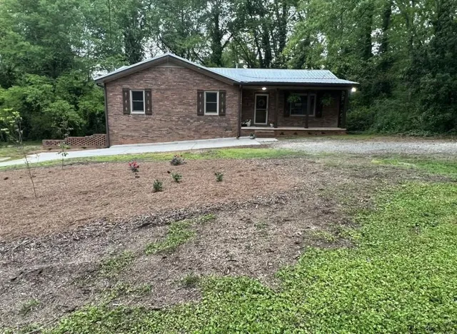 a kitchen with granite countertop wooden floors sink and stove