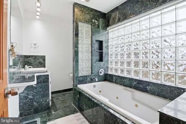 a bathroom with a granite countertop bathtub and a shower