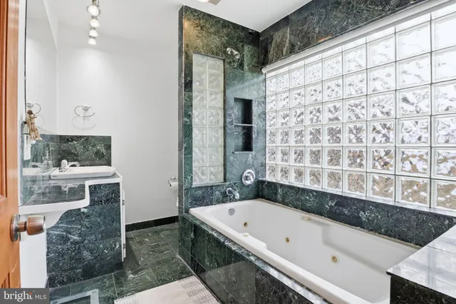 a bathroom with a granite countertop bathtub and a shower