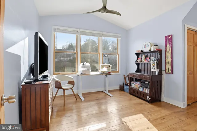 a living room with furniture a flat screen tv and a floor to ceiling window