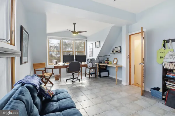 a living room with furniture a dining table and large windows