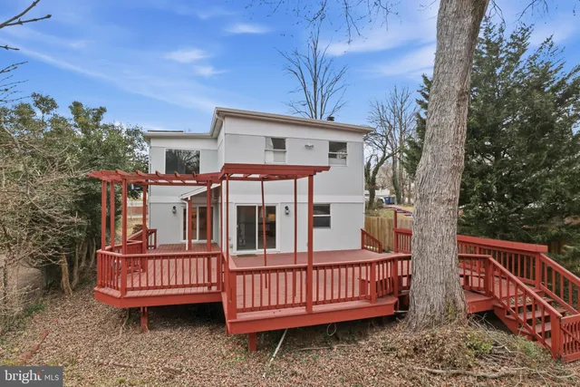 a view of a house with a deck and furniture