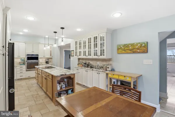 a kitchen with a stove a refrigerator and a stove top oven