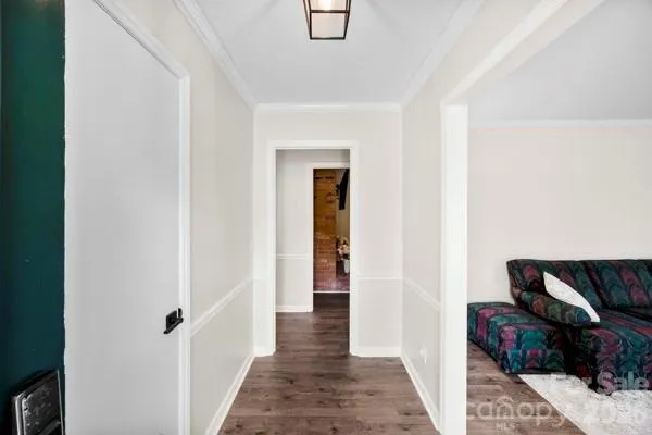 a view of a hallway with wooden floor and furniture