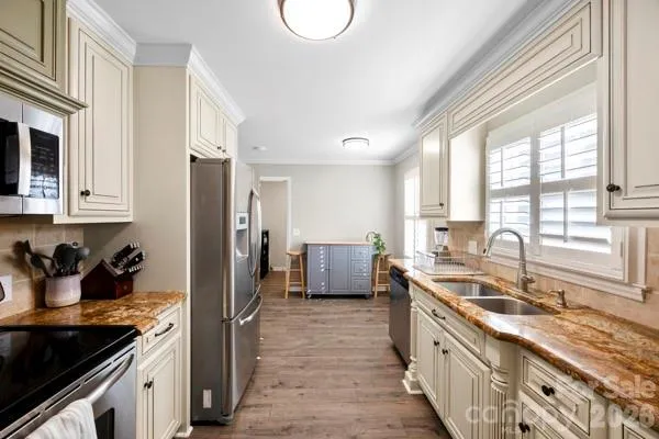 a kitchen with stainless steel appliances a stove a sink a refrigerator and cabinets
