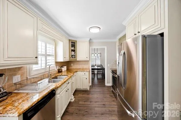 a large kitchen with a refrigerator a sink a stove and cabinets