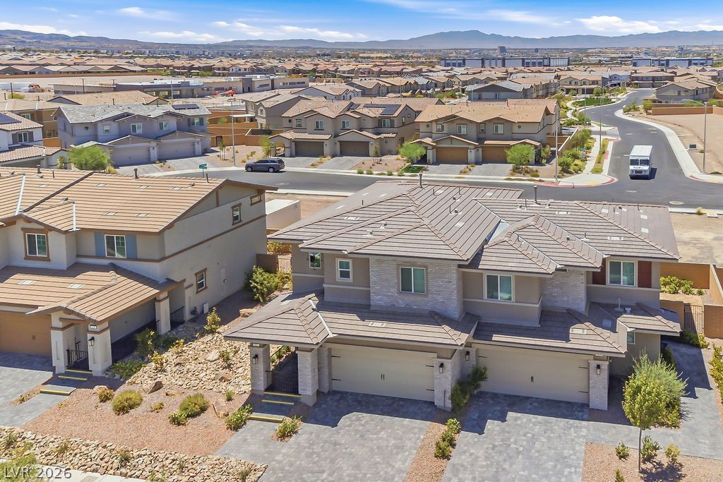 913 Cadence View Way Henderson, NV 89011 - Photo 4 of 46 Discover a spacious modern residence featuring a dual garage and ample parking, surrounded by a thoughtfully designed desert landscape.
