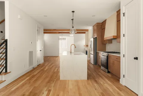 a kitchen with kitchen island a counter top space a sink and stainless steel appliances