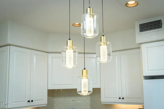 a open kitchen with stainless steel appliances granite countertop a stove a sink dishwasher a dining table and chairs with wooden floor