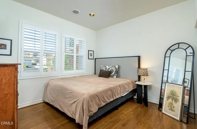 a bedroom with a large bed and a potted plant