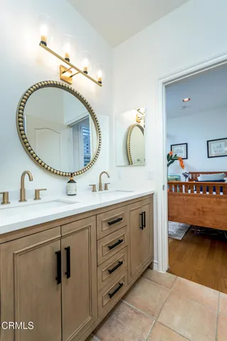 a en suite bathroom with a granite countertop sink and a mirror