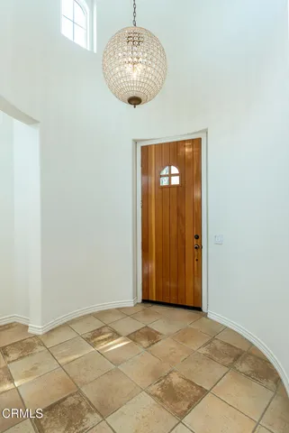 a view of an empty room with a chandelier fan