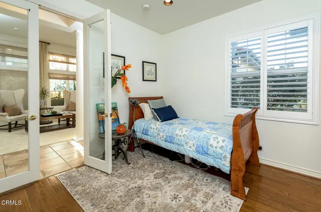 a bedroom with bed and wooden floor