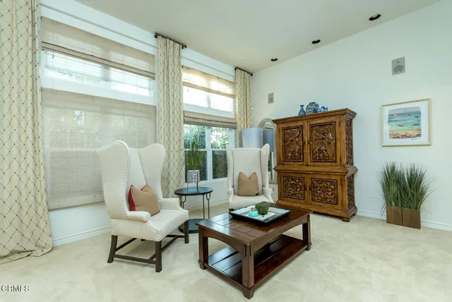a living room with furniture a flat screen tv and a floor to ceiling window