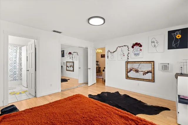 a bedroom with a bed and painting on the wall