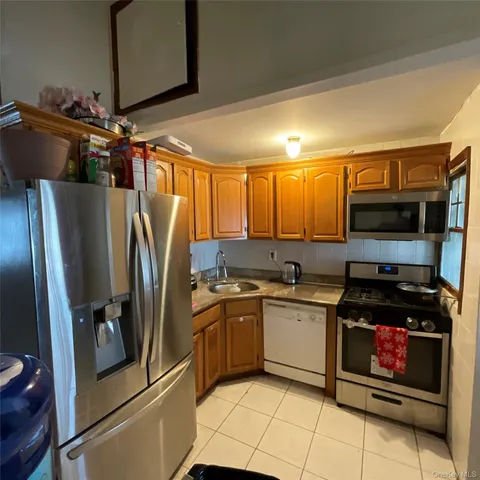 a kitchen with stainless steel appliances a refrigerator sink and microwave
