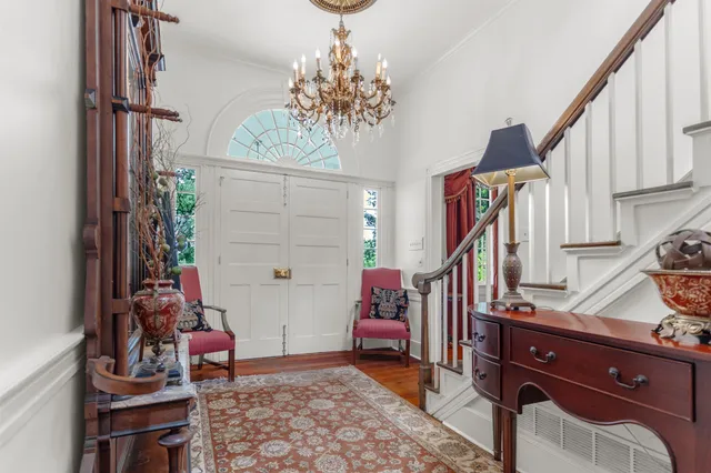 a dining room with furniture a chandelier and wooden floor